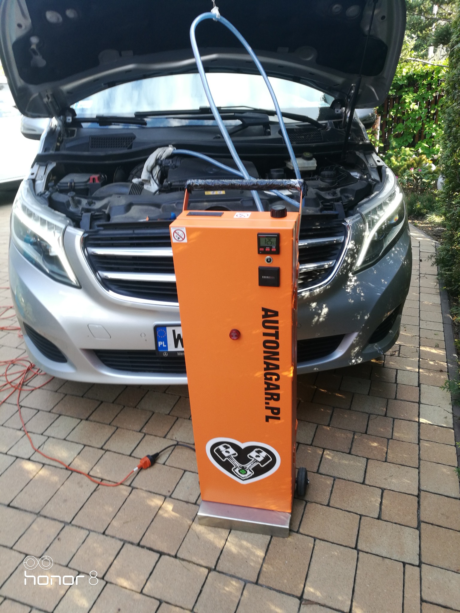 Wodorowanie silnika Mercedes CDI przy użyciu pomarańczowego urządzenia Autonagar.pl, widoczny otwarty silnik i węże podłączone do urządzenia.