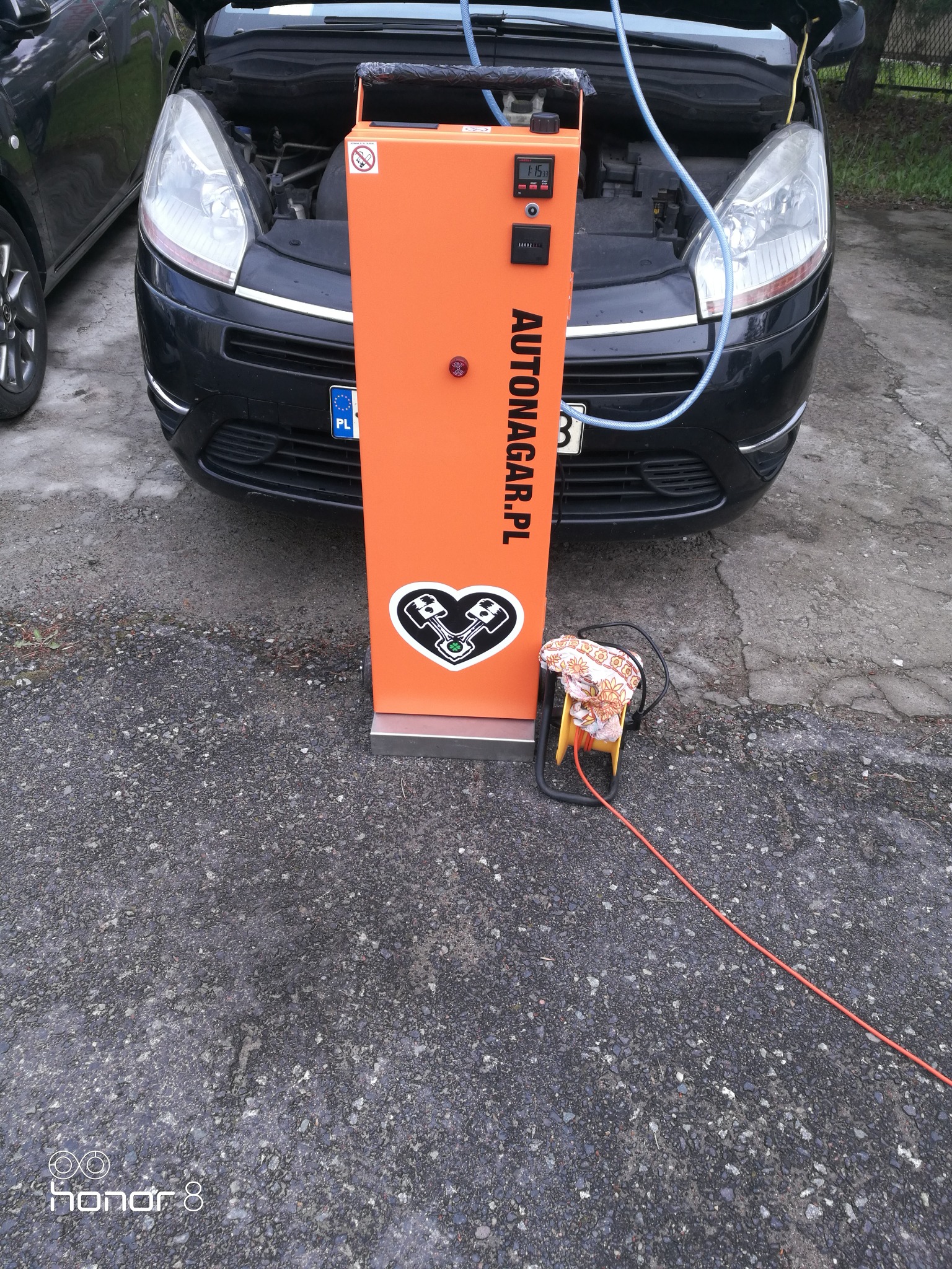 Czarny Citroen z otwartą maską podczas procesu wodorowania silnika przy użyciu pomarańczowego urządzenia z napisem AUTONAGAR.PL i logotypem serca z tłokami.