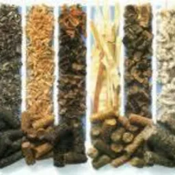 Różne rodzaje pelletu i surowców do jego produkcji, ułożone w pionowe pasy, od jasnych trocin po ciemny pellet, prezentacja asortymentu.