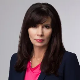 Portret kobiety w marynarce na jasnym tle, Grodzisk Mazowiecki. Profesjonalny wizerunek z delikatnym makijażem i ciemnymi włosami.