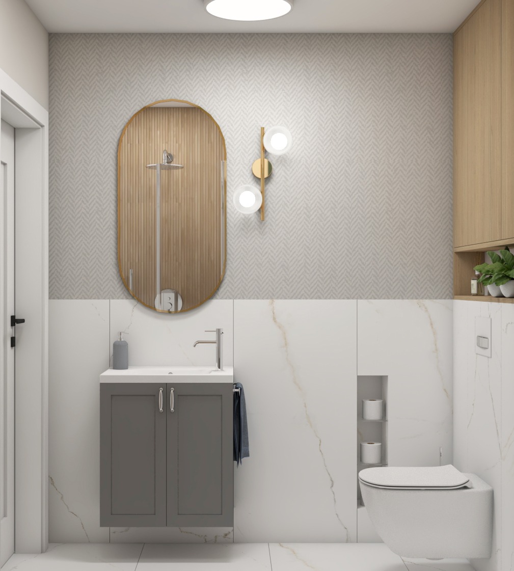 Nowoczesna łazienka z szarą szafką pod umywalką, owalnym lustrem w złotej ramie, białymi płytkami imitującymi marmur i geometryczną tapetą w odcieniach beżu.