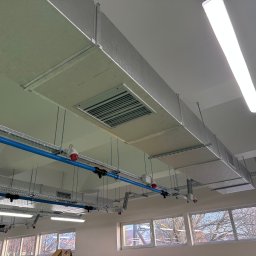 GoHVAC - Kompleksowa instalacja wentylacji mechanicznej z izolowanymi kanałami PIR, widoczna pod sufitem, z elementami regulacji temperatury nawiewu i oświetleniem LED.
