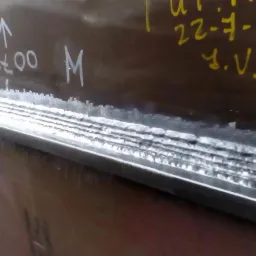 Spoina wielowarstwowa na metalowej konstrukcji z widocznymi oznaczeniami naniesionymi pisakiem.