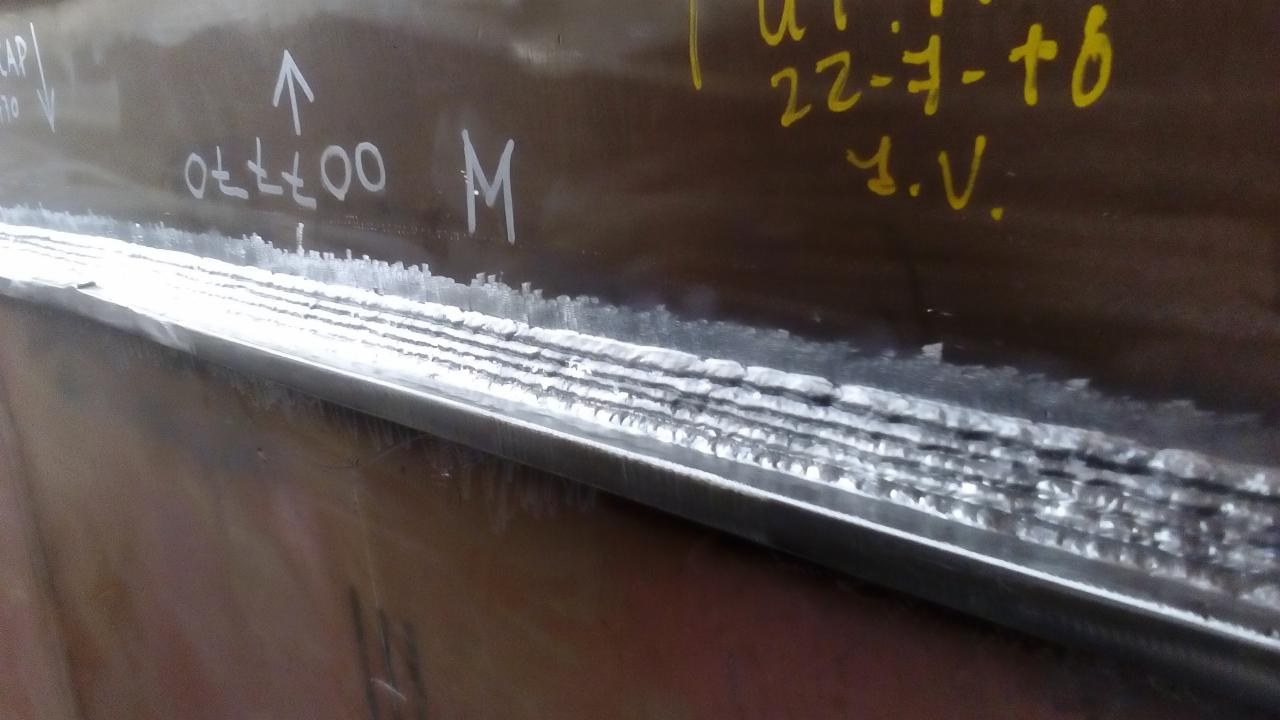 Spoina wielowarstwowa na metalowej konstrukcji z widocznymi oznaczeniami naniesionymi pisakiem.