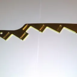 Precyzyjnie wykonana, złota, metalowa listwa z ząbkowanym brzegiem i otworami, leżąca na białym tle.