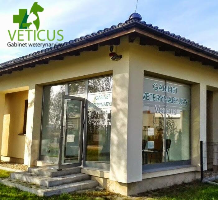 Budynek gabinetu weterynaryjnego 'Veticus' w Szamotułach, z otwartymi szklanymi drzwiami wejściowymi i widocznymi reklamami na oknach.