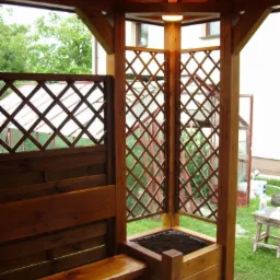 Drewniana altana z ławką i donicą, oświetlona ciepłym światłem, z widokiem na zieleń w tle. Elementy kratki i solidna konstrukcja podkreślają rzemieślniczy charakter.