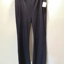 Ciemne, damskie spodnie dresowe z metką, wiszące na wieszaku na tle jasnej ściany, oferowane w Nowym Tomyślu.