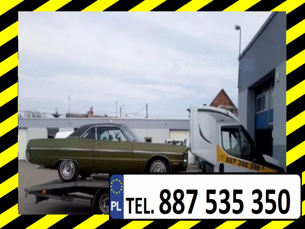 Zielony, klasyczny samochód osobowy na platformie lawety, obok biały samochód dostawczy z numerem telefonu, na tle budynku.