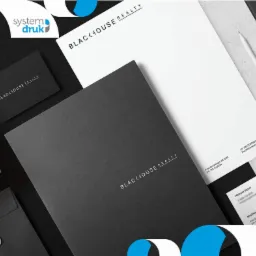 Zestaw materiałów firmowych Blackhouse Realty: wizytówka, papier firmowy, teczka i koperta, z logo System Druk w rogu.