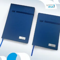 Dwa identyczne, granatowe kalendarze książkowe z gumką i metalową plakietką z logo firmy NPA Northern Group, rok 2019, leżące na białym tle z elementami grafiki.