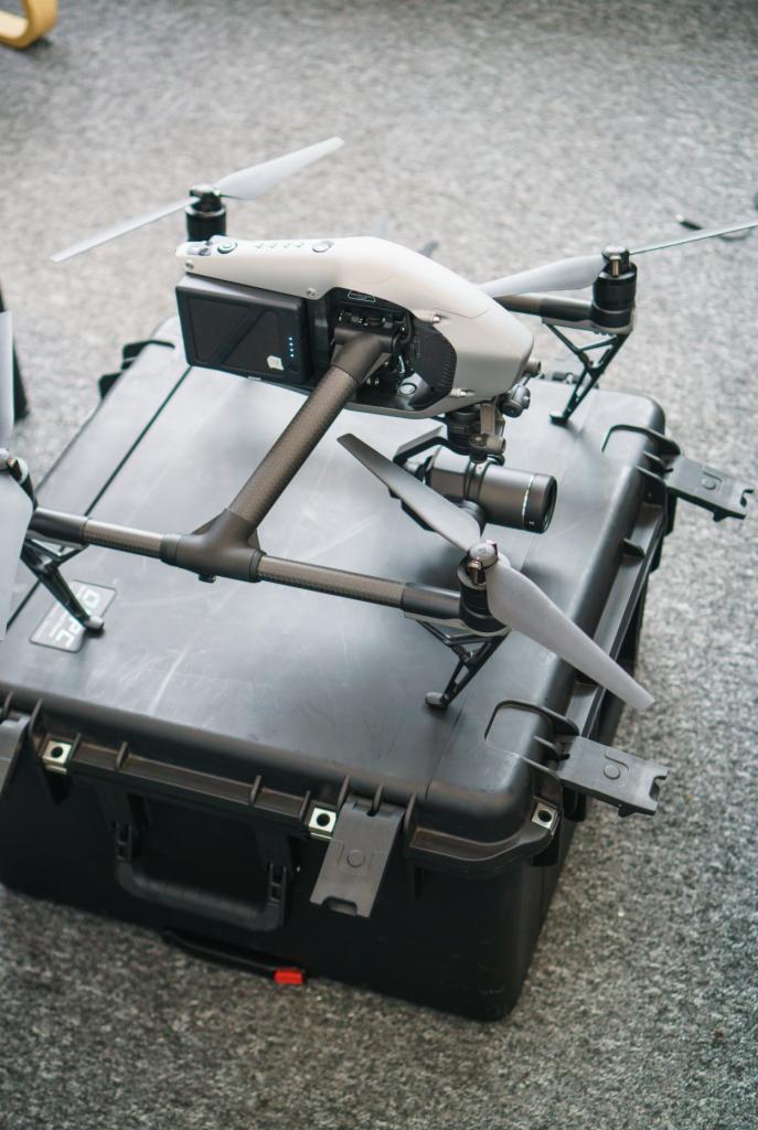 Profesjonalny dron z kamerą na czarnym, solidnym case transportowym z widocznymi zatrzaskami i mocowaniami, gotowy do filmowania.