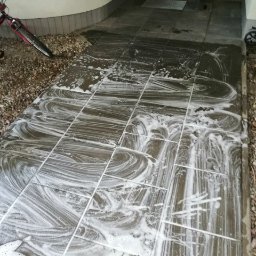 AGRA - Czyszczenie kostki brukowej przed wejściem do budynku, widoczne ślady piany po umyciu pod ciśnieniem.