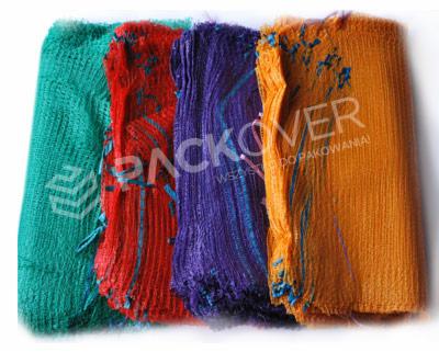 Kolorowe siatki do pakowania: zielona, czerwona, fioletowa i pomarańczowa, ułożone obok siebie na białym tle, widoczne detale faktury i delikatne niebieskie akcenty na pomarańczowej siatce.