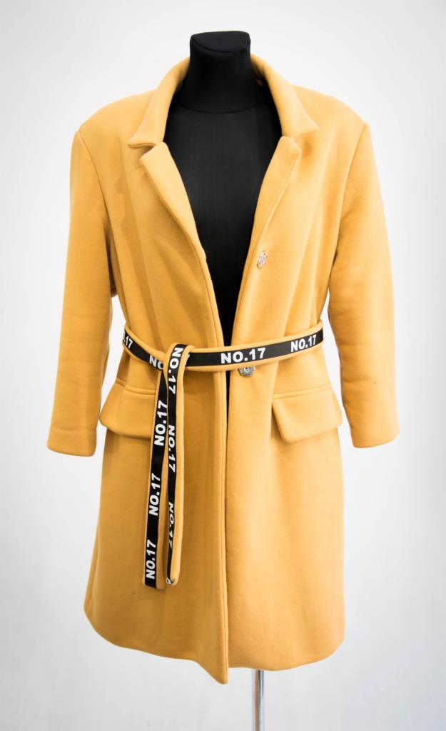 Żółty płaszcz damski z czarnym paskiem z napisem NO.17, prezentowany na czarnym manekinie na białym tle.