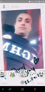 Zdjęcie selfie mężczyzny z filtrami i naklejkami nałożonymi na obraz. Widoczny interfejs aplikacji z opcjami edycji. Oświetlenie naturalne.