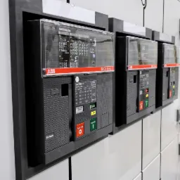 Szyna z zamontowanymi wyłącznikami elektrycznymi ABB SACE Emax 2, widoczne przyciski włączania i wyłączania oraz oznaczenia parametr&oacute;w technicznych.