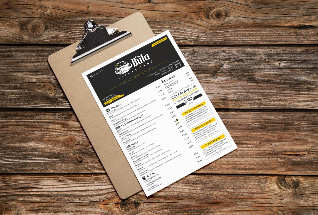 Menu restauracji Pan Buła Street Food na desce z klipsem, leżące na drewnianym blacie stołu.