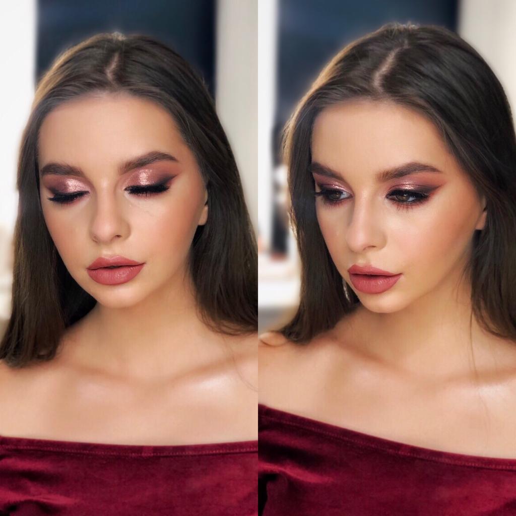 Portret kobiety z profesjonalnym, błyszczącym makijażem oczu w odcieniach różu i brązu, oraz matowymi ustami w kolorze dusty rose, ubrana w bordową bluzkę z odkrytymi ramionami.