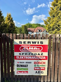 Tablica reklamowa serwisu elektronarzędzi ELMA na drewnianym płocie, z logo marek Bosch, DeWalt, Makita i Hilti. W tle zieleń i budynek.