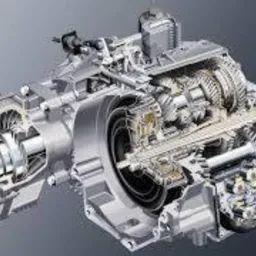 Przekrój skrzyni biegów samochodowej ukazujący skomplikowany mechanizm zębatek i wałów, oświetlony studyjnie na szarym tle.