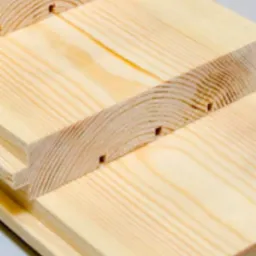 Profilowane deski z jasnego drewna, widoczne połączenia pióro-wpust, ułożone jedna na drugiej.