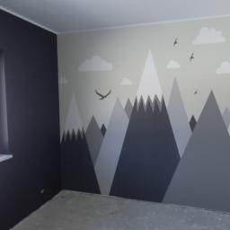 USŁUGI OGÓLNOBUDOWLANE KEN-BUD MACIEJ KĘDZIERSKI - Pokój z pomalowaną ścianą w motywy górskie i lecących ptaków, obok ściana w kolorze grafitowym z oknem, surowa podłoga.