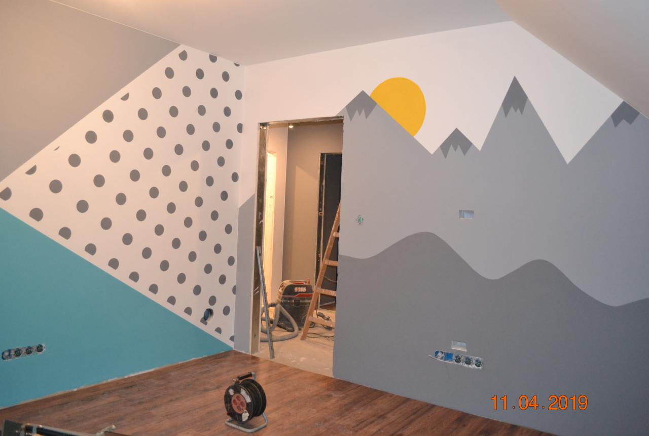 Pokój dziecięcy po malowaniu: ściany z motywem gór, słońca i kropek, widoczne narzędzia malarskie i data wykonania prac.