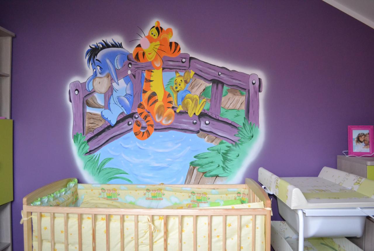 Ręcznie malowana scena z Kubusia Puchatka na fioletowej ścianie w pokoju dziecięcym, widoczny fragment łóżeczka i przewijaka.
