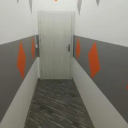 Korytarz po malowaniu ścian w geometryczne wzory: szare pasy i pomarańczowe romby, szara podłoga z płytek, białe ściany i drzwi.