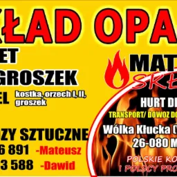 Żółto-czarny baner reklamowy składu opału oferującego pellet, ekogroszek, węgiel, miał i nawozy sztuczne, z numerami telefonów kontaktowych i adresem firmy.