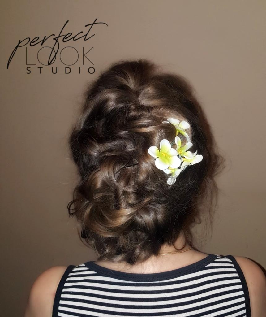 Upięcie włosów z wplecionymi białymi kwiatami, widok z tyłu, na karku delikatny złoty łańcuszek.