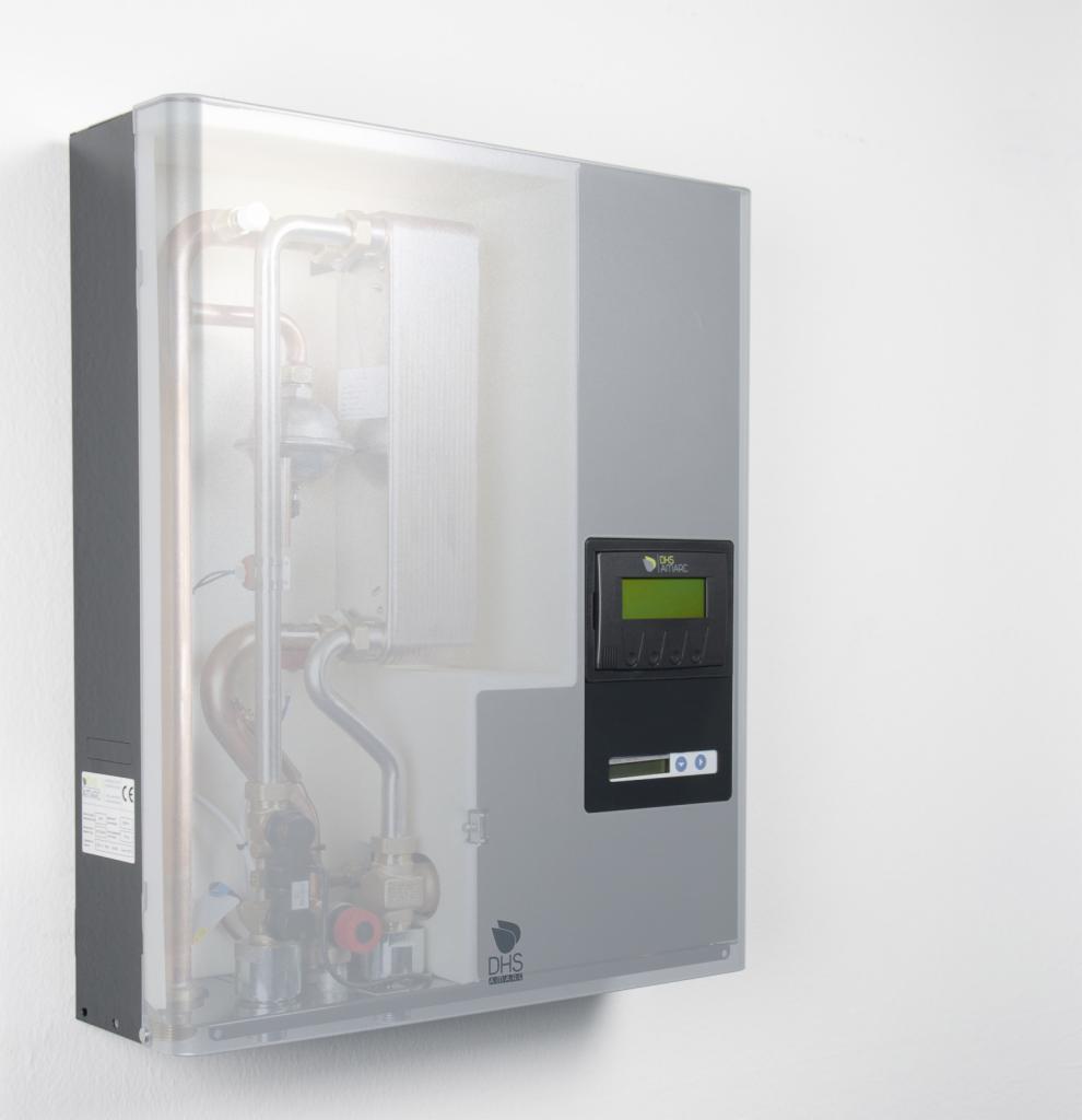 Szary piec z przezroczystą osłoną na ścianie, widoczne rury i elementy wewnętrzne, panel sterowania z wyświetlaczem i przyciskami, logo DHS na dole.