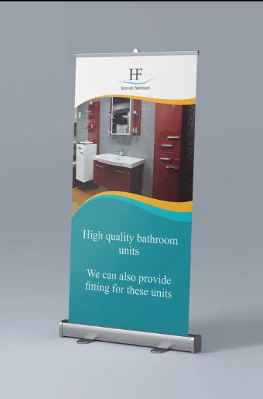 Rozwinięty roll-up reklamowy prezentujący aranżację łazienki z czerwonymi szafkami i białą umywalką, z logo 'Heaven Furniture' w górnej części.