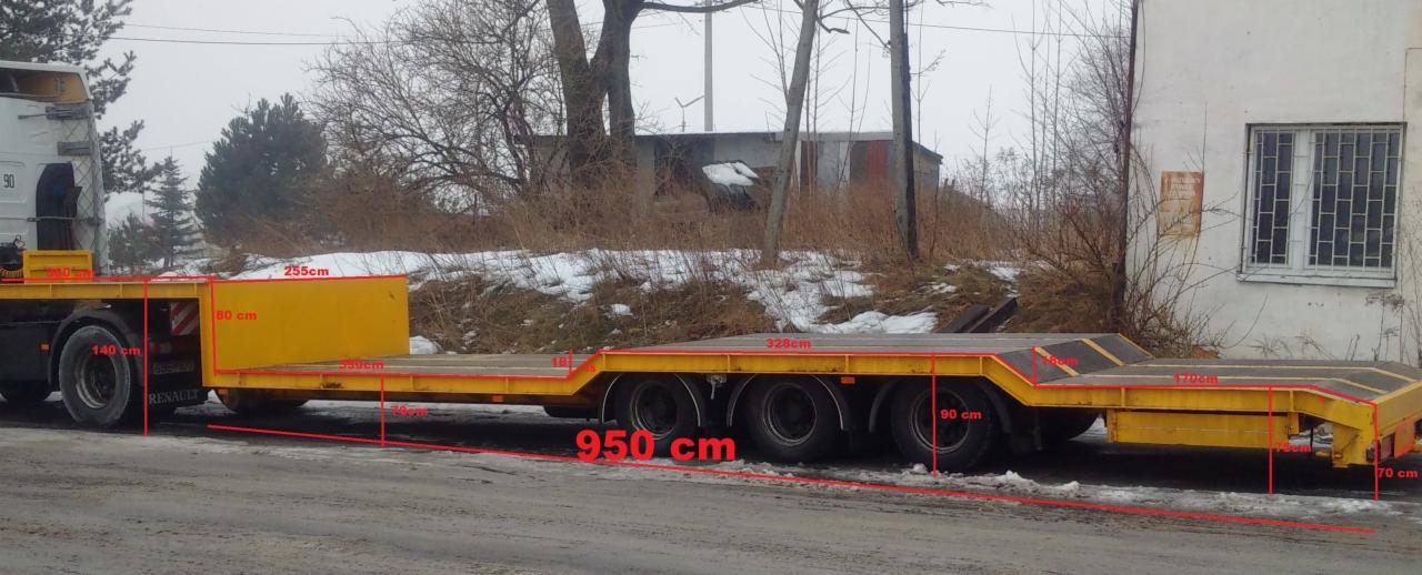 Żółta naczepa niskopodwoziowa z naniesionymi wymiarami, stojąca na szosie w pochmurny dzień.