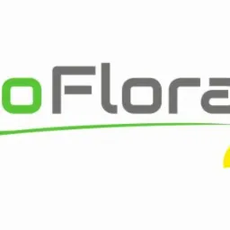 Logo firmy ProFlora z zielonym napisem 'Pro' i szarym 'Flora', zieloną linią pod napisem oraz stylizowanym kwiatem z szarymi, żółtymi i zielonymi płatkami.