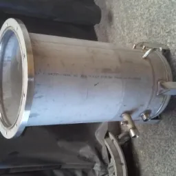 Cylindryczny zbiornik ze stali nierdzewnej z widocznymi spawami, umieszczony na szarym, teksturowanym podłożu, z napisem 'Made in Finland'.