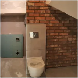 Łazienka w trakcie remontu w Sępopolu: widoczna ściana z płyt kartonowo-gipsowych z instalacją elektryczną oraz fragment wykończonej ściany z cegły i podwieszana toaleta.