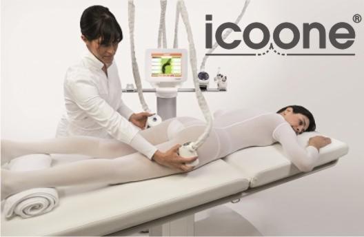 Kobieta w białym kombinezonie leży na leżance podczas zabiegu ICOONE wykonywanego przez kosmetyczkę w białym uniformie, widoczne logo ICOONE