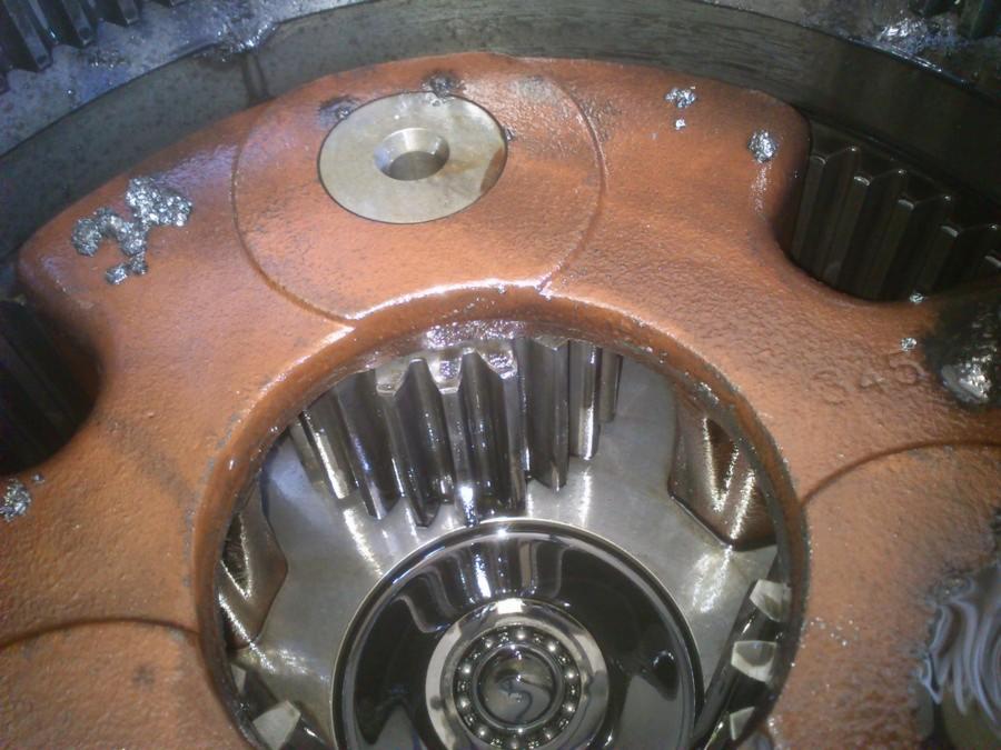 Obrabiana przekładnia zębata w oleju, widoczne ślady obróbki skrawaniem i numer seryjny 345.