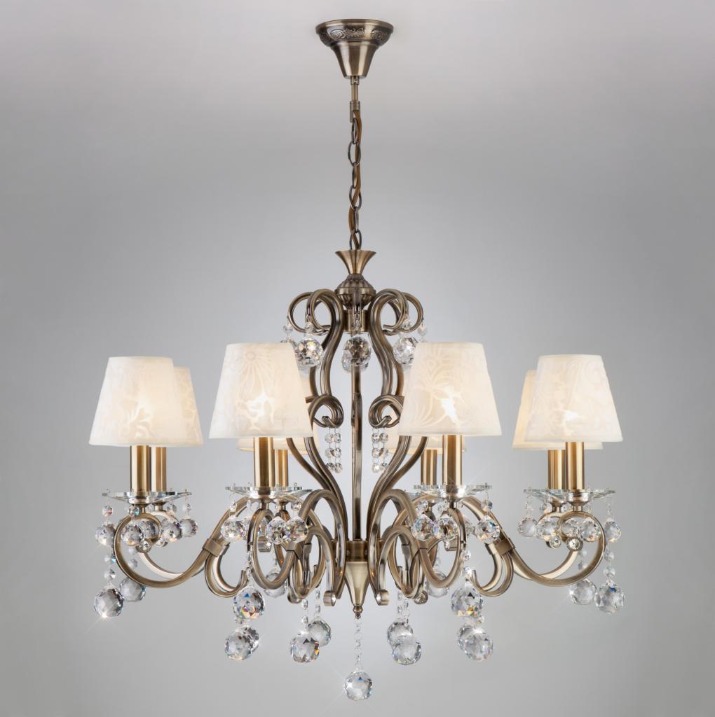 Elegancki żyrandol w stylu retro z sześcioma abażurami w kwiatowy wzór i kryształowymi zawieszkami, zawieszony na łańcuchu.