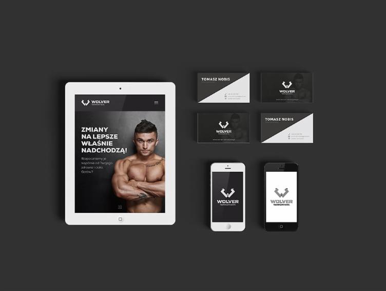 Mockup prezentujący identyfikację wizualną firmy Wolver: logo na tablecie, smartfonach oraz wizytówki z motywem sportowym i wizerunkiem umięśnionego mężczyzny.