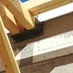 Stal-Spaw - Drewniana konstrukcja dachu zamocowana do ściany z betonu komórkowego za pomocą stalowego łącznika na śruby.