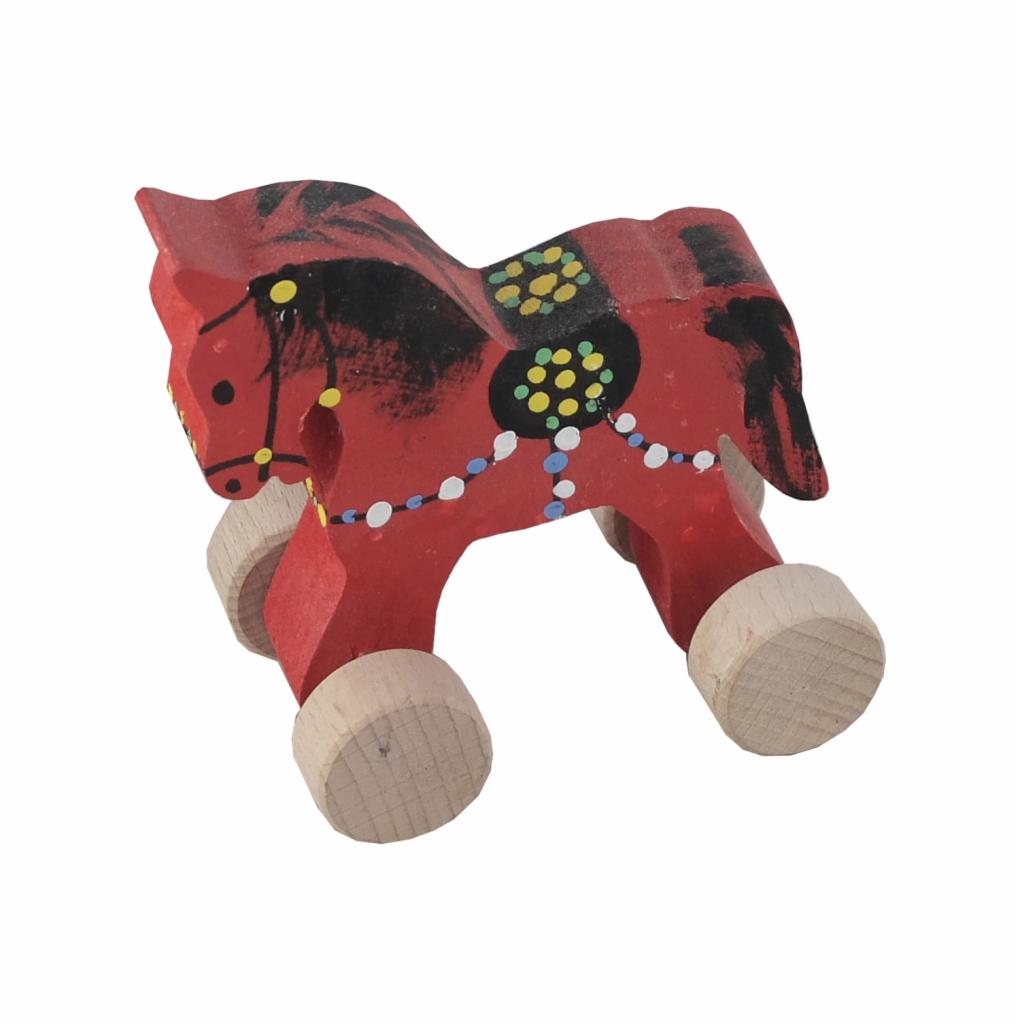 Czerwony, drewniany konik na kółkach z ręcznie malowanymi, kolorowymi wzorami, na białym tle.