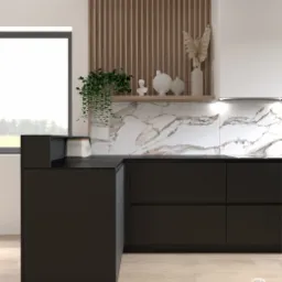 Minimalistyczna kuchnia z czarnymi szafkami, marmurowym backsplashiem i drewnianymi lamelami na ścianie, uzupełniona o rośliny i dekoracyjne wazony na półce.