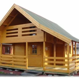 Gotowy drewniany domek letniskowy z balkonem i zielonym dachem, prezentowany na betonowych bloczkach.