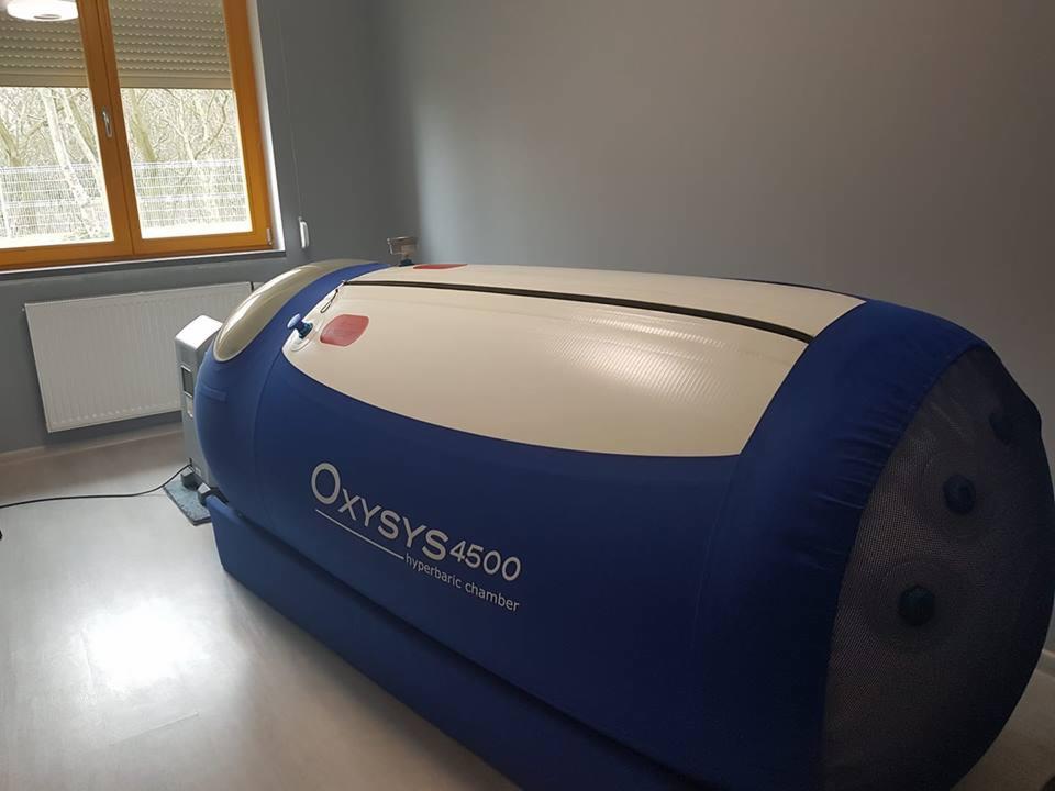 Oksygenowa komora hiperbaryczna Oxysys 4500 w jasnym pomieszczeniu z oknem, widok z boku.