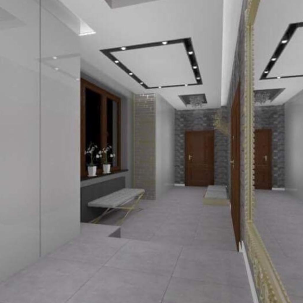 Nowoczesny przedpokój z szarą podłogą z płytek, białymi ścianami, oknem z roślinami w doniczkach, ławką i lustrem w ozdobnej złotej ramie, z dekoracyjnym oświetleniem sufitowym.