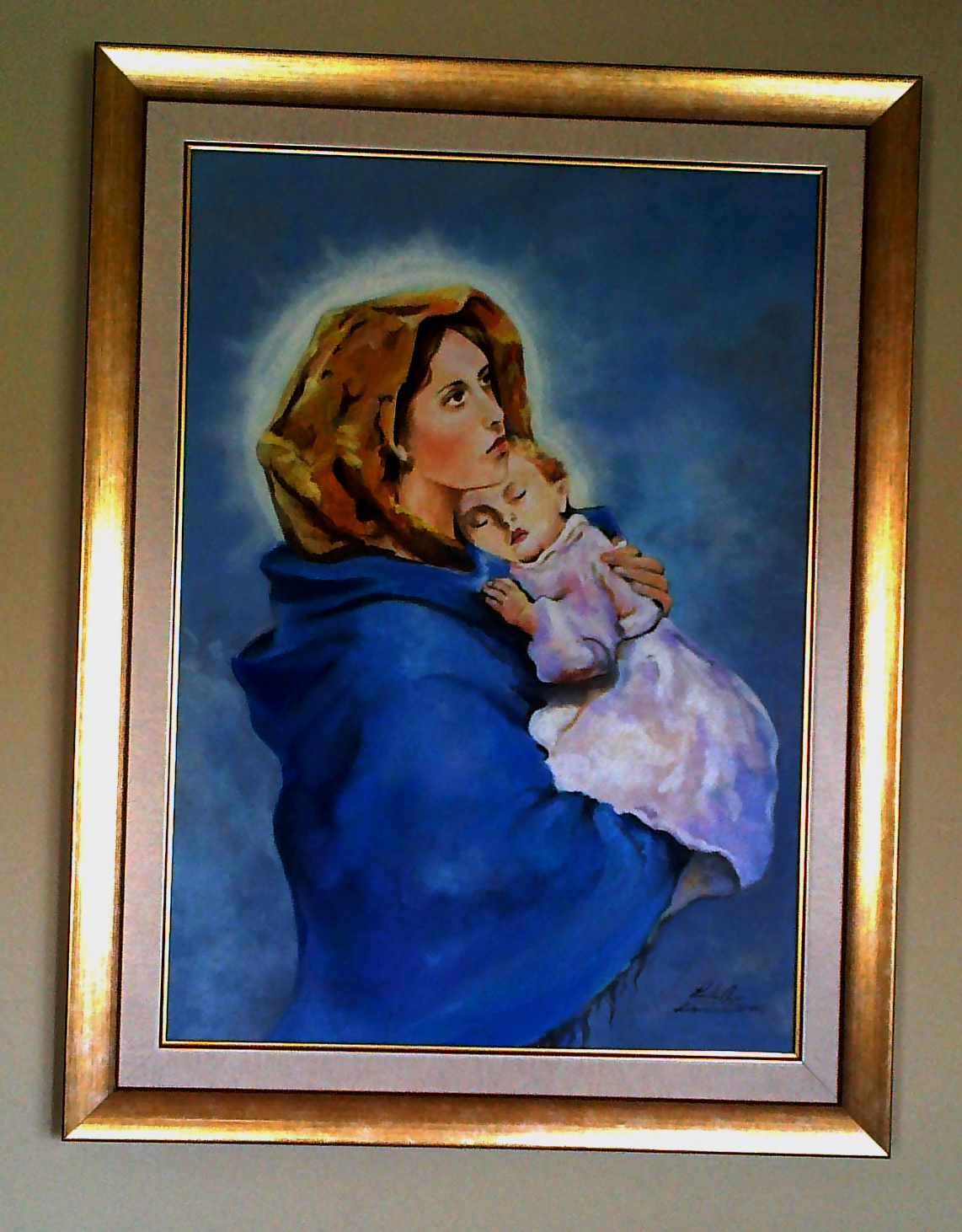 Obraz olejny w złotej ramie przedstawiający Matkę Boską z Dzieciątkiem na niebieskim tle.