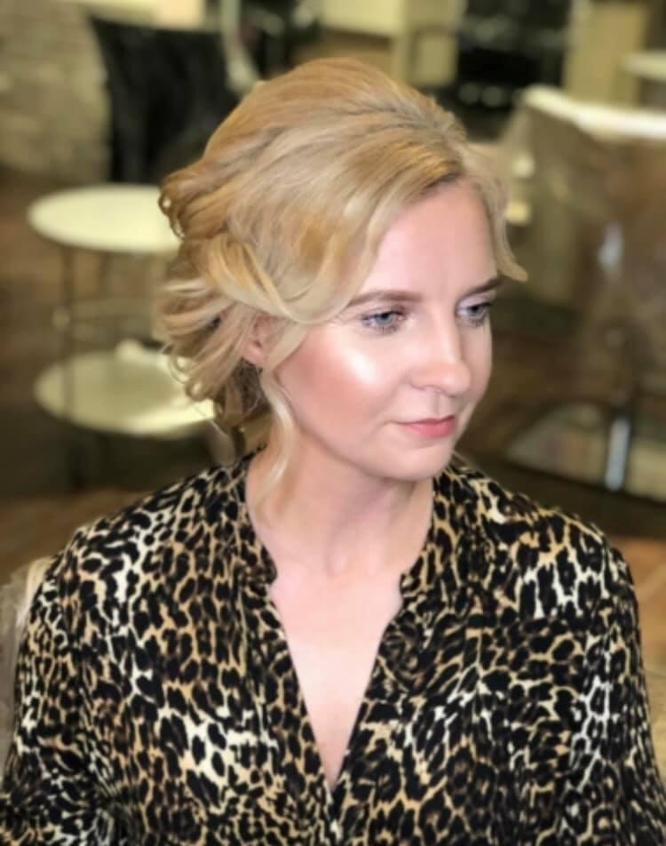 Portret blondynki z upiętymi włosami i delikatnym makijażem w bluzce w panterkę, wykonany w salonie.